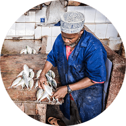 Man processing fish, representing local commerce